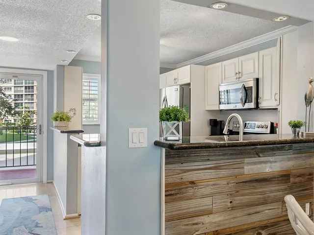 a kitchen with stainless steel appliances granite countertop a stove microwave and refrigerator