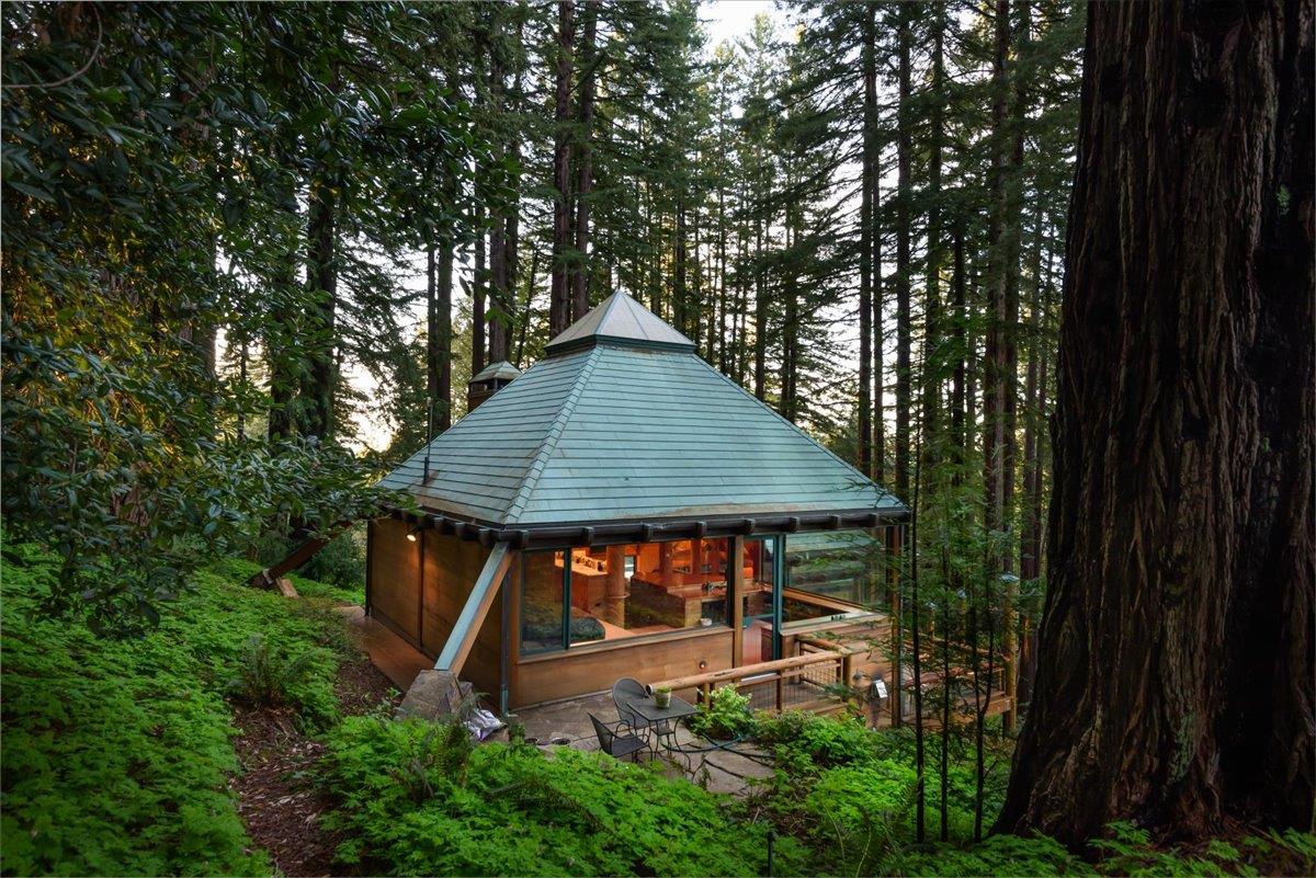 9 Summit Road Woodside, CA 94062 - Photo 33 of 38 a backyard of a house with table and chairs under an umbrella