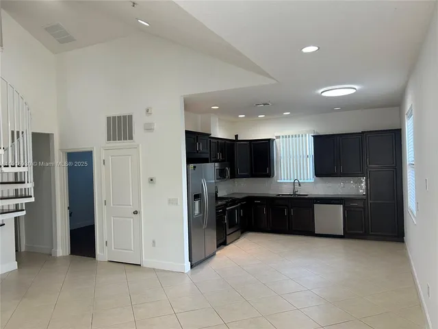 a view of an empty room with a fireplace and a window