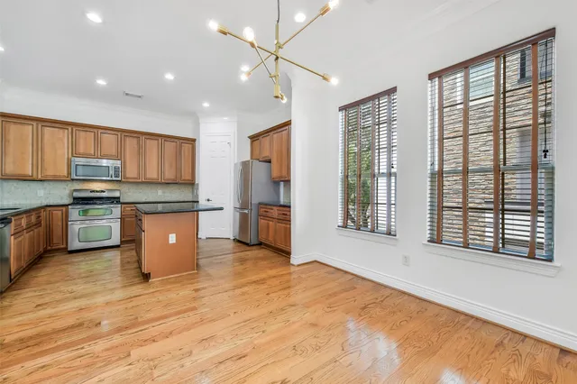 a view of empty room with wooden floor and window