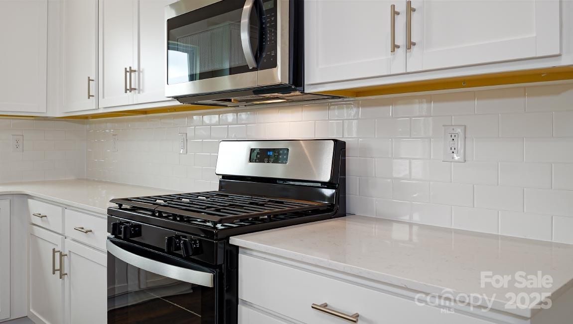 269 Shorthorn Road Fletcher, NC 28732 - Photo 6 of 23 a kitchen with granite countertop a stove and a white cabinets