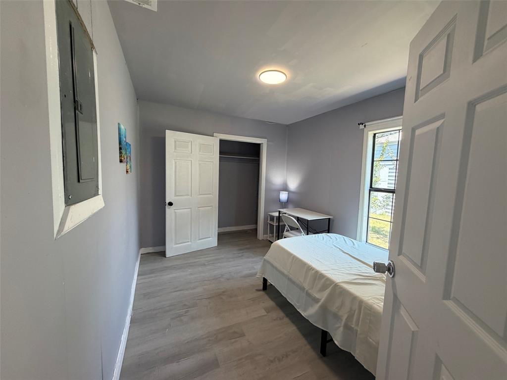 513 Shawnee Trace Grand Prairie, TX 75051 - Photo 18 of 32 Room featuring wood-finish flooring, light gray walls, and a visible window for natural illumination