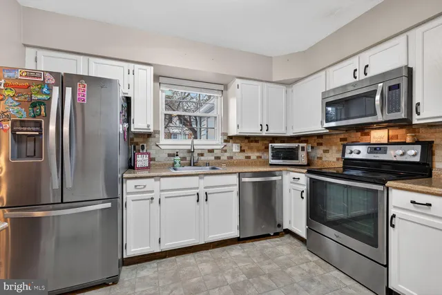 a kitchen with stainless steel appliances granite countertop a refrigerator stove a sink and a microwave