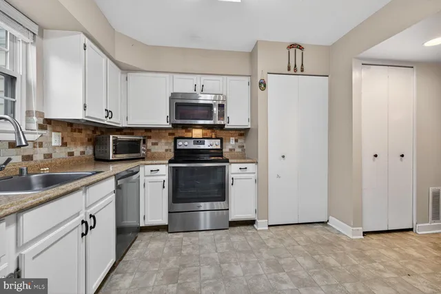 a kitchen with stainless steel appliances a refrigerator sink and microwave