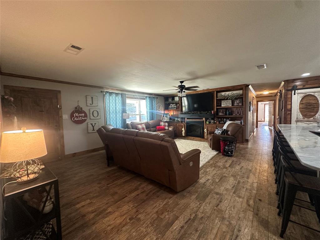 101 Twin Creek Road Comanche, TX 76442 - Photo 12 of 28 a living room with furniture a fireplace and a flat screen tv