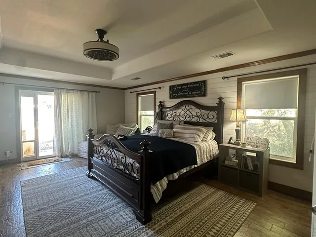 a large bed sitting in a bedroom next to a window and a chandelier