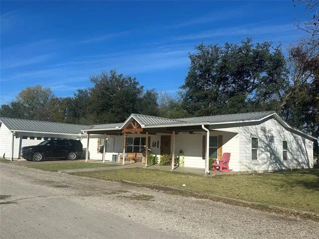 a front view of a house with a yard and trees