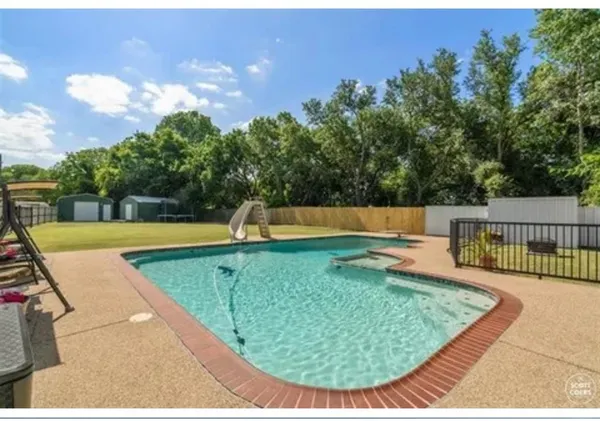 a view of a swimming pool with a patio and a yard