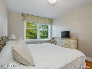 201 Shore Road Greenwich, CT 06830 - Photo 24 of 29 a bedroom with a large bed and a flat tv screen on dresser