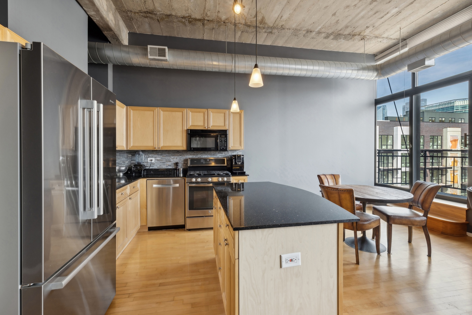 843 West Adams Street, Unit 606 Chicago, IL 60607 - Photo 3 of 12 a kitchen with stainless steel appliances granite countertop a stove top oven a sink a dining table and chairs