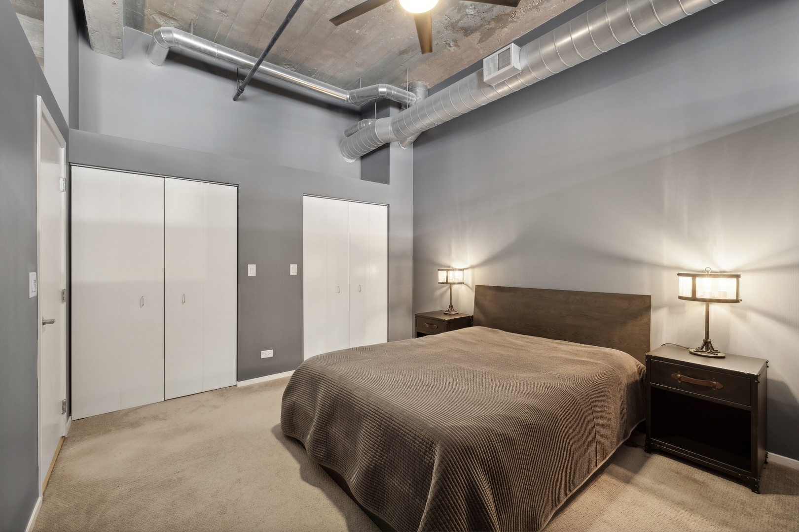 843 West Adams Street, Unit 606 Chicago, IL 60607 - Photo 8 of 12 a spacious bedroom with a bed and a lamp