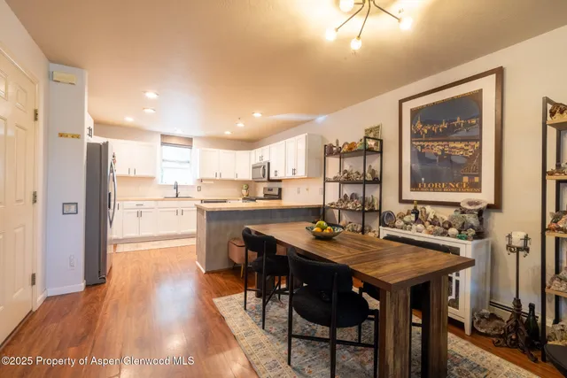 a kitchen with a table chairs refrigerator and cabinets