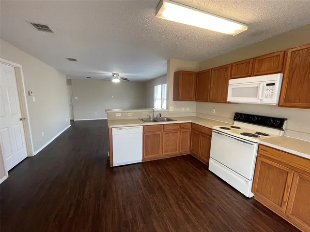 a kitchen with a sink cabinets stainless steel appliances and a window