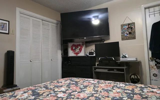 a bedroom with a bed and a flat screen tv