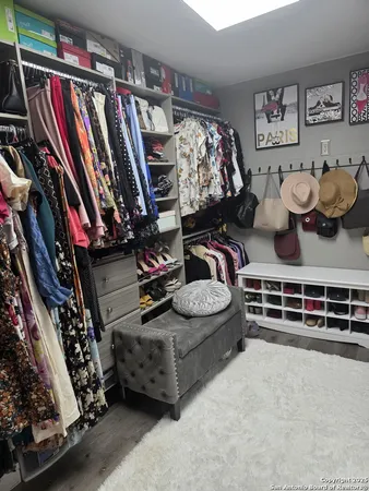 a view of walk in closet with clothes and shoes