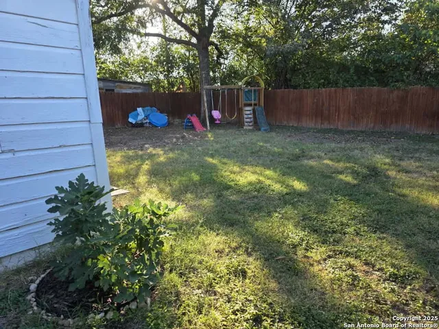 a view of a backyard with a small cabin and hardwood