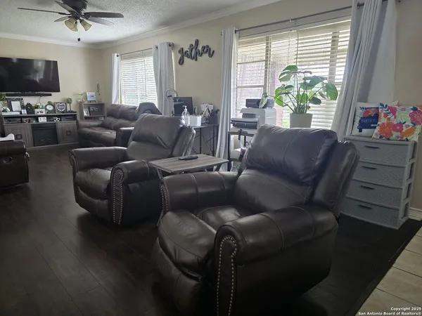 a living room with furniture a flat screen tv and a window