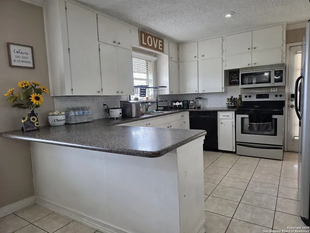 a kitchen with stainless steel appliances granite countertop a sink dishwasher stove top oven and cabinets