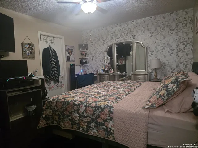 a bedroom with a bed dresser and a flat tv screen