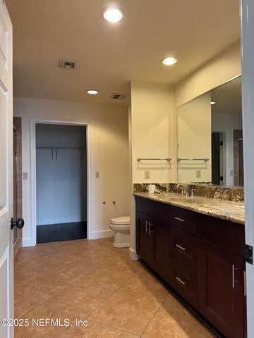 a bathroom with a granite countertop sink mirror and toilet