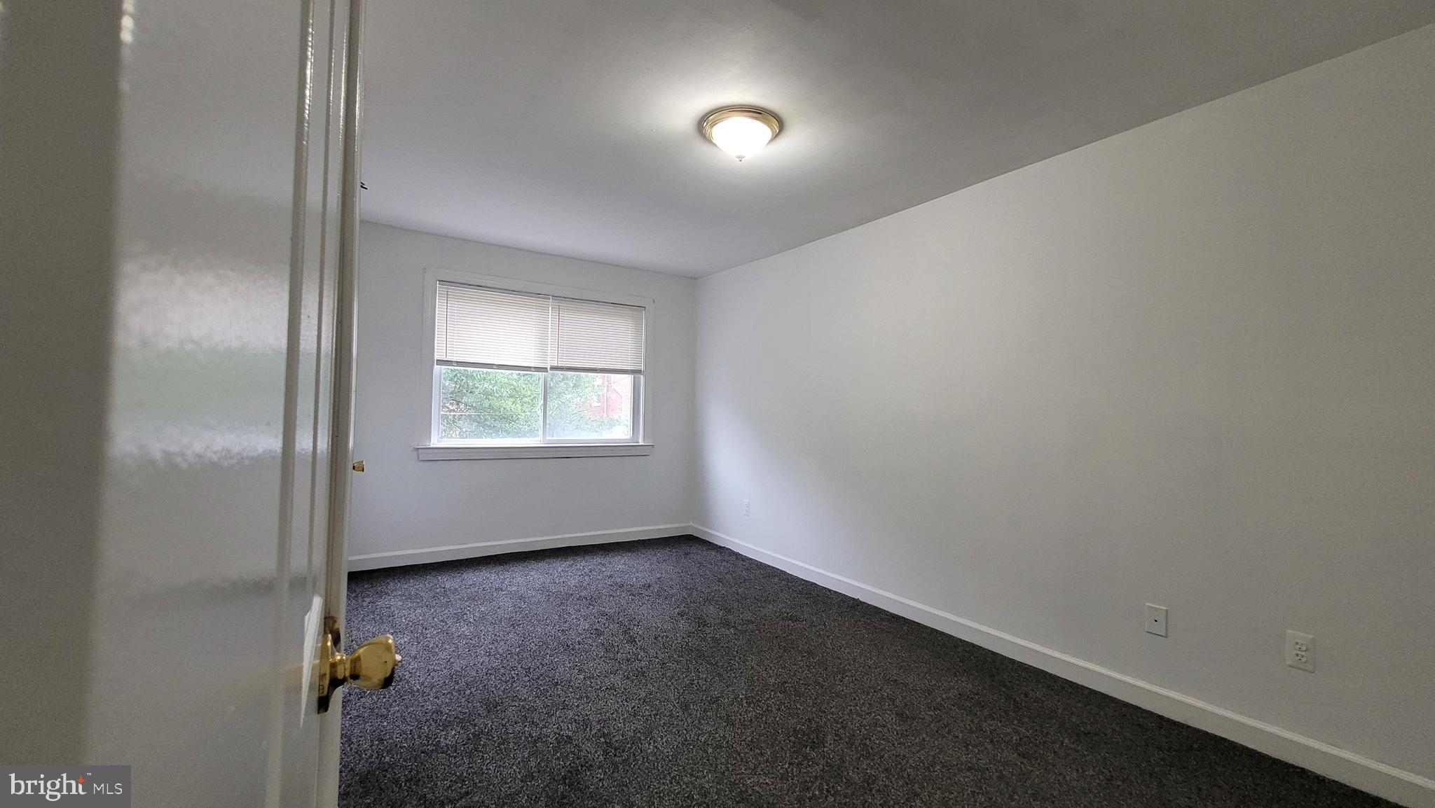 705 Brandywine Street Southeast, Unit 201 Washington, DC 20032 - Photo 11 of 15 an empty room with windows