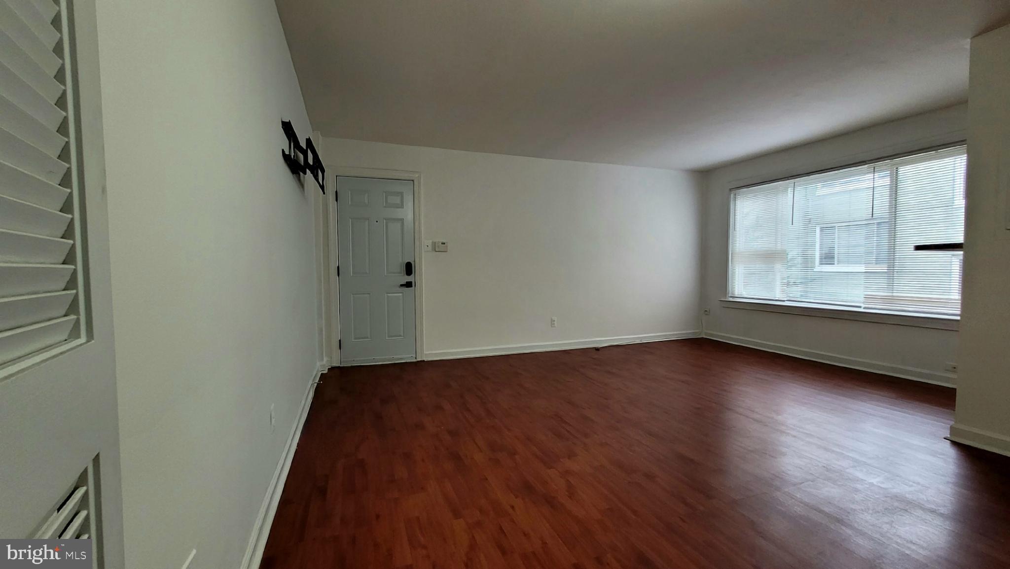 705 Brandywine Street Southeast, Unit 201 Washington, DC 20032 - Photo 4 of 15 wooden floor in an empty room with a window