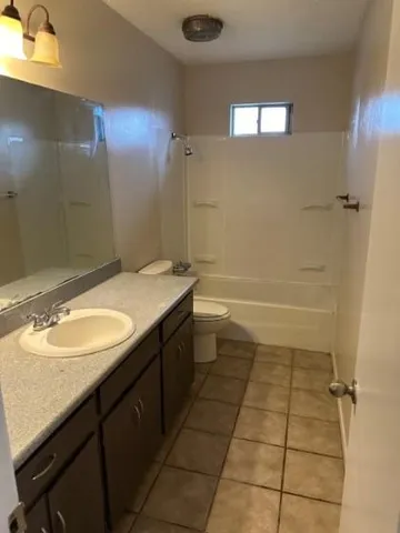 a bathroom with a granite countertop sink a toilet and shower