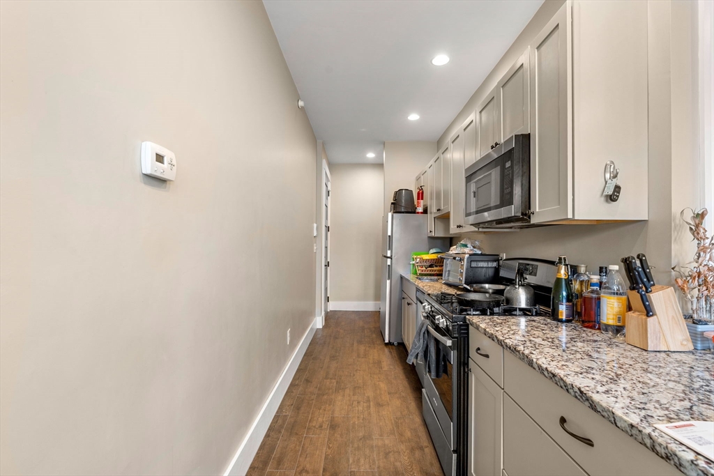 1149 Middlesex Street, Unit 4 Lowell, MA 01851 - Photo 3 of 6 a kitchen with stainless steel appliances granite countertop a sink a stove top oven a refrigerator and dishwasher