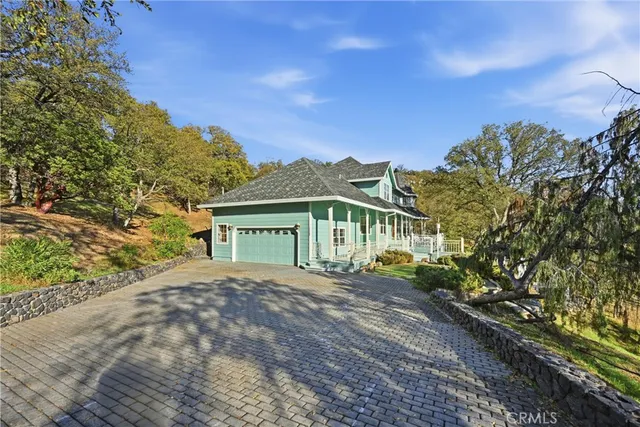 a front view of a house with a yard and trees