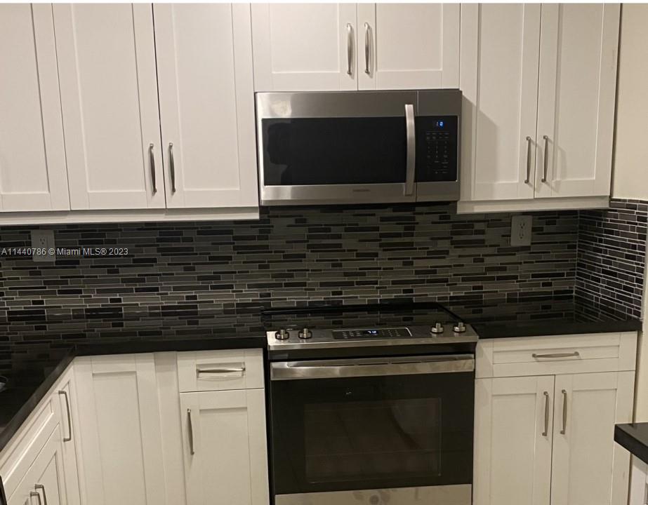 721 North Pine Island Road, Unit 304 Plantation, FL 33324 - Photo 20 of 22 a kitchen with stainless steel appliances a stove a microwave and cabinets