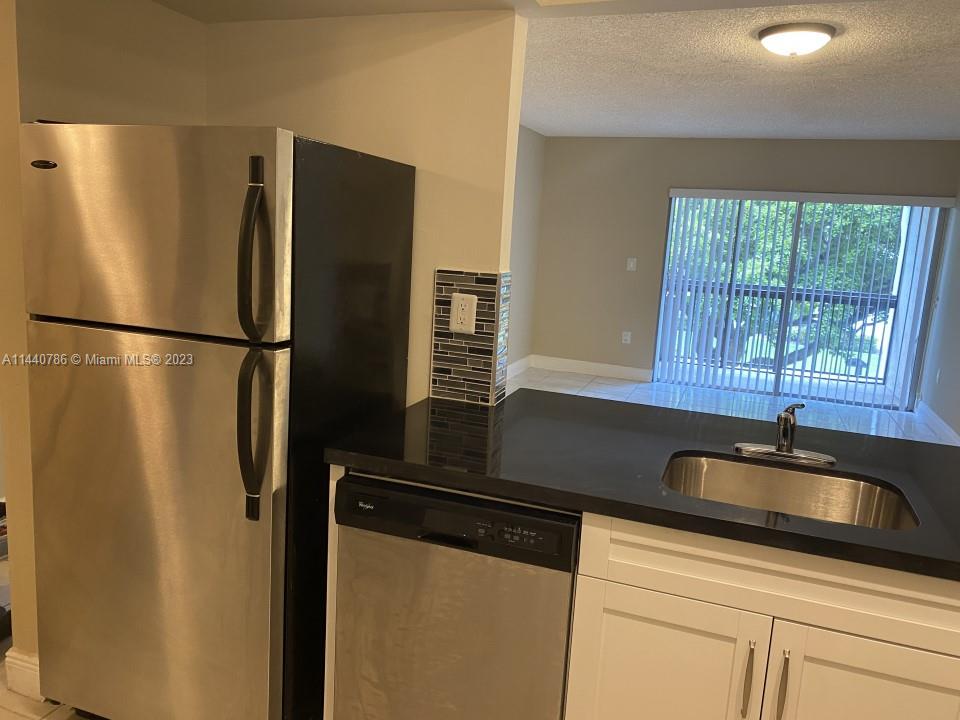 721 North Pine Island Road, Unit 304 Plantation, FL 33324 - Photo 7 of 22 a kitchen with a refrigerator and a sink