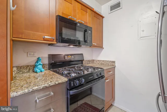 a kitchen with stainless steel appliances granite countertop a stove and a microwave