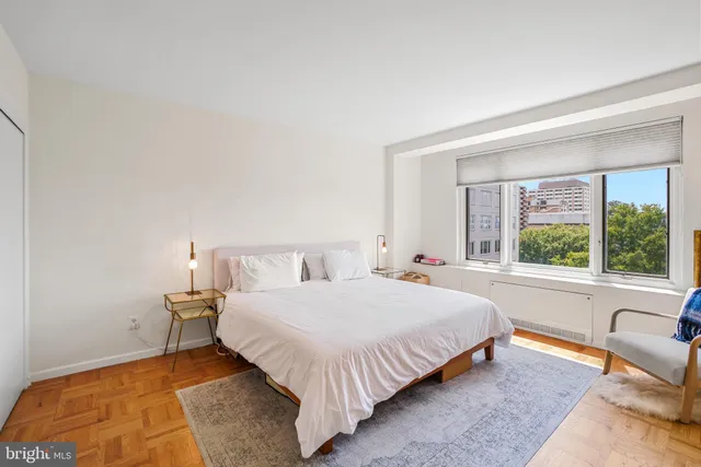 a bedroom with a bed and a large window