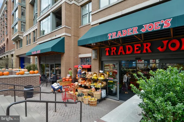 a group of people sitting in front of retail shops