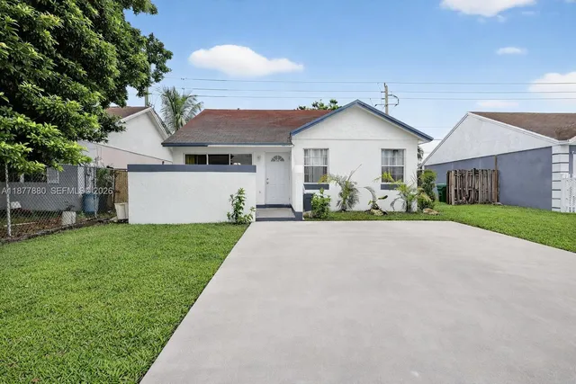 a view of a house with a yard and large tree
