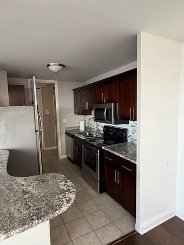 a large kitchen with a stove a refrigerator and a sink