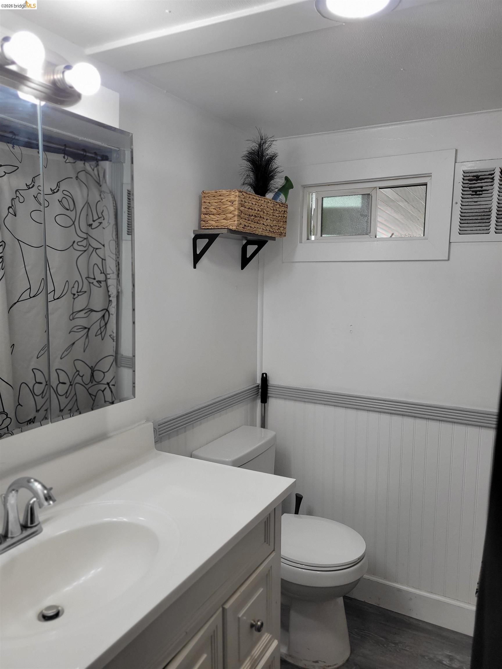 4400 Gateway Road, Unit 38 Bethel Island, CA 94511 - Photo 4 of 5 Bathroom featuring vanity, dark wood finished floors, wainscoting, and curtained shower