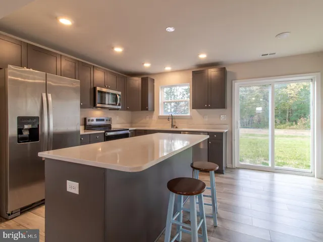 a kitchen with kitchen island a sink stainless steel appliances and window