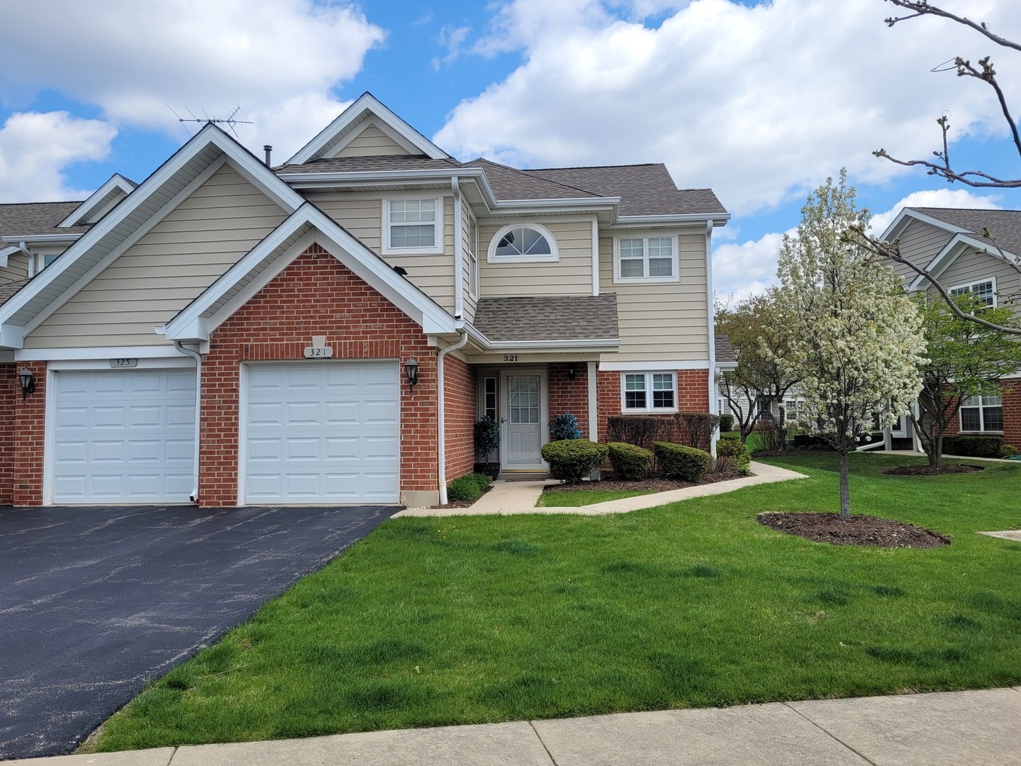 321 Sheffield Drive, Unit 321 Schaumburg, IL 60107 - Photo 17 of 21 a front view of a house with a yard and garage