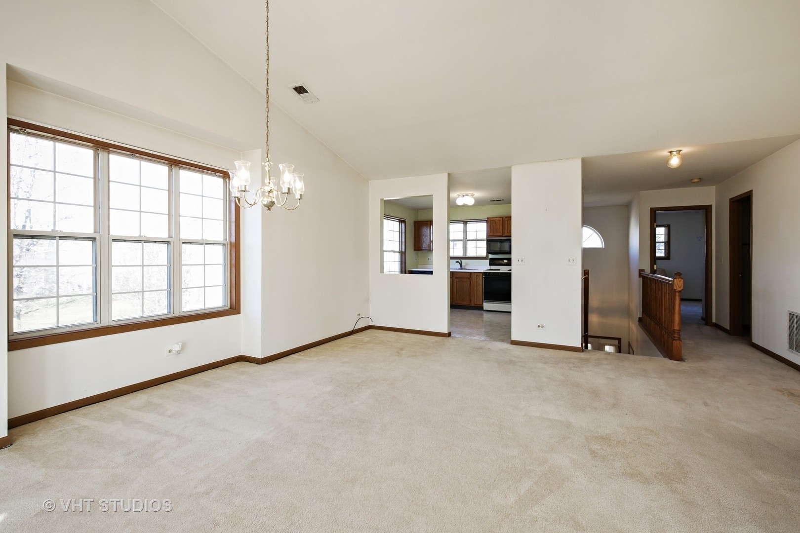 321 Sheffield Drive, Unit 321 Schaumburg, IL 60107 - Photo 3 of 21 an empty room with windows and chandelier