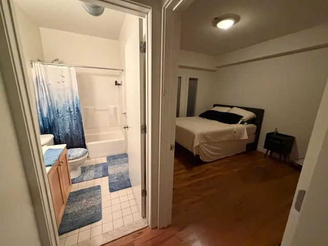a bedroom with a bed and wooden floor