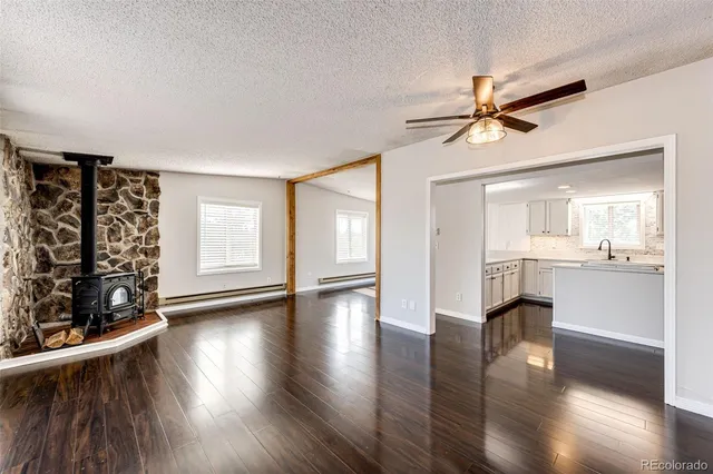 an empty room with windows and fan