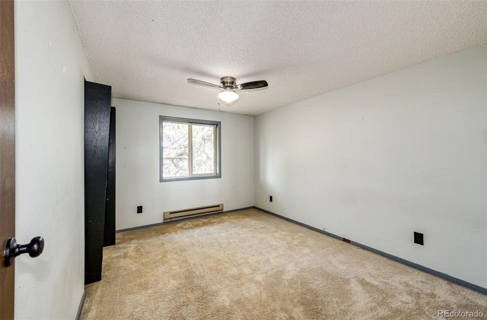 7417 Rafter Road Franktown, CO 80116 - Photo 16 of 37 an empty room with windows and fan