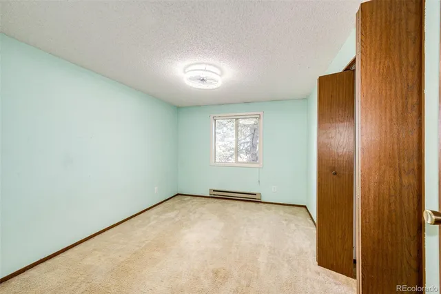 a view of a livingroom with a chandelier fan and windows