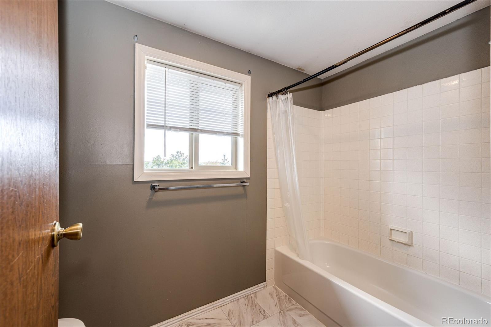 7417 Rafter Road Franktown, CO 80116 - Photo 21 of 37 a bathroom with a bathtub and a shower