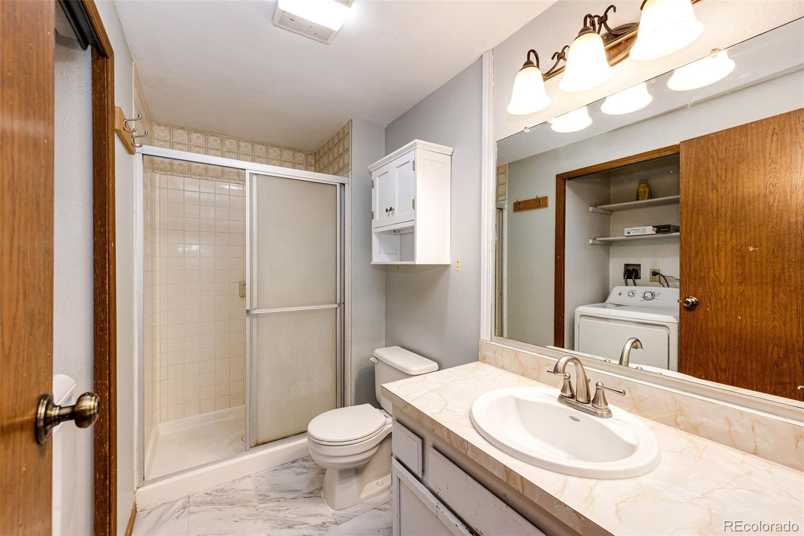 7417 Rafter Road Franktown, CO 80116 - Photo 23 of 37 a bathroom with a sink toilet and shower