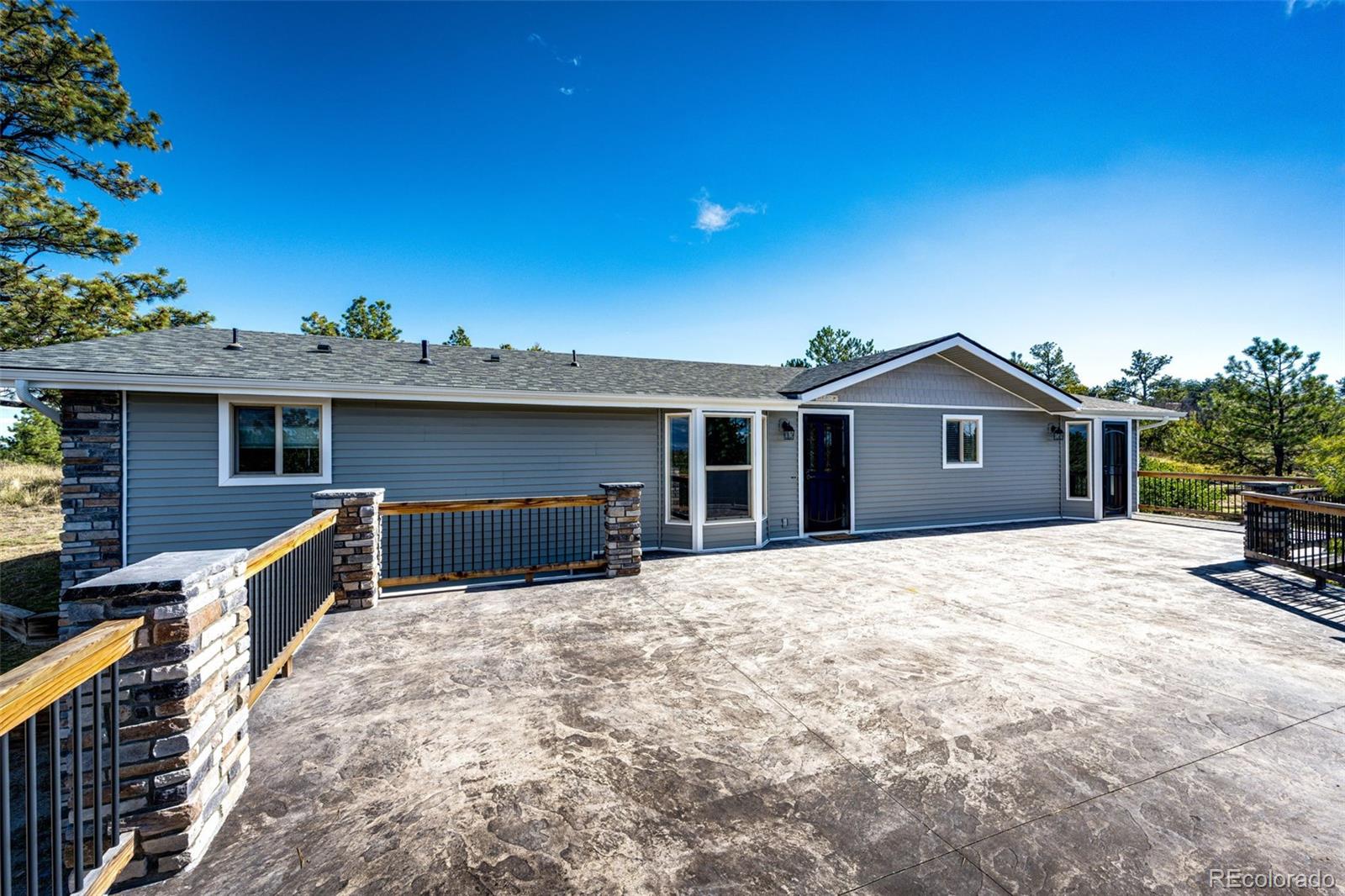 7417 Rafter Road Franktown, CO 80116 - Photo 6 of 37 a front view of a house with a yard and garage