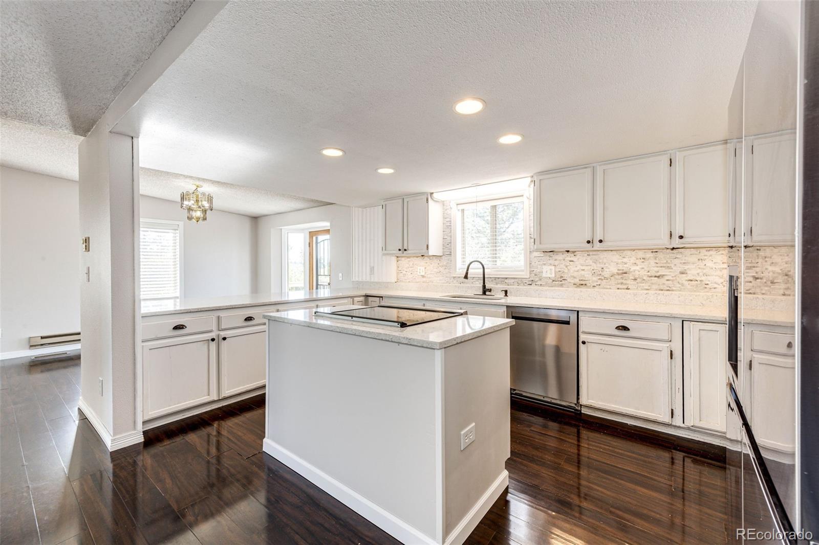 7417 Rafter Road Franktown, CO 80116 - Photo 9 of 37 a kitchen with granite countertop white cabinets and white appliances