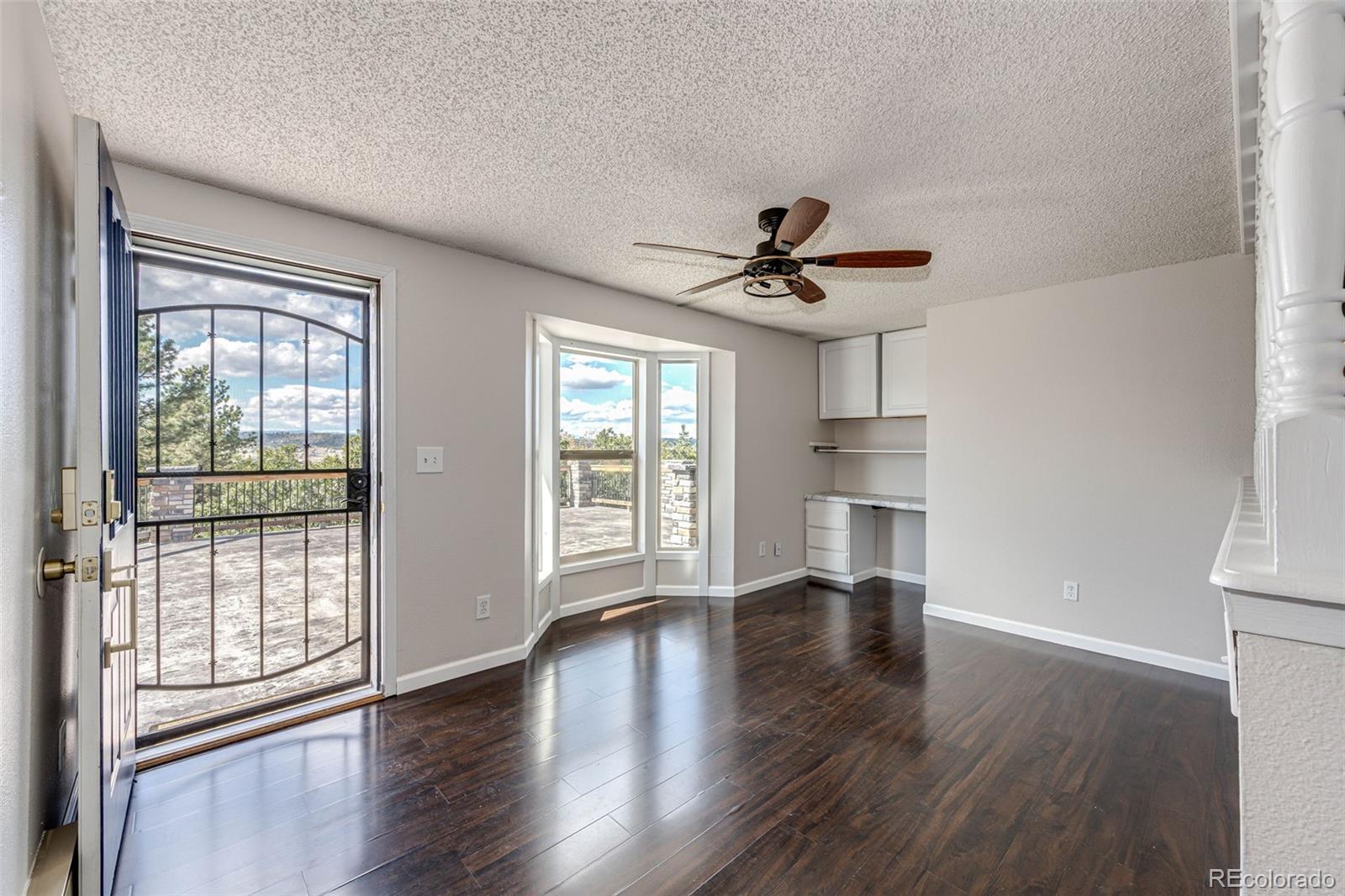 7417 Rafter Road Franktown, CO 80116 - Photo 10 of 37 a view of an empty room with a window and wooden floor