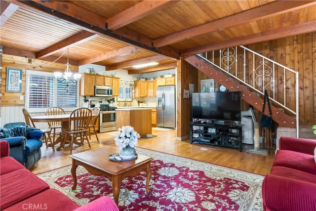 a kitchen with granite countertop a sink stainless steel appliances wooden floor and a counter top space